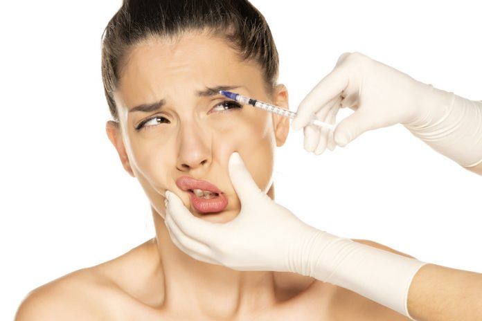 Portrait Of A Young Frightened Woman On A Face Filler Injection Procedure