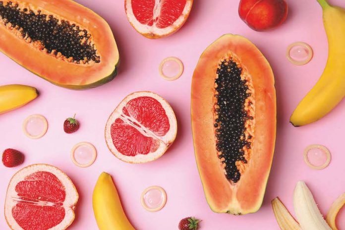 Flat Lay Composition With Condoms And Exotic Fruits On Pink Background. Erotic Concept