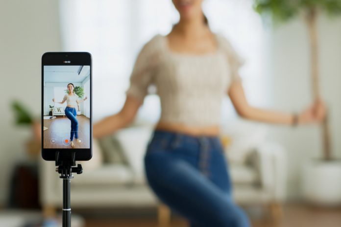 Asian Young Woman Created Her Dancing Video By Smartphone Camera. To Share Video To Social Media Application.